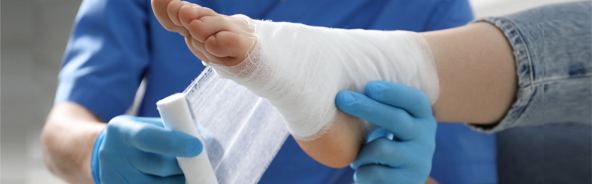 Doctor bandaging patient's foot in clinic, closeup